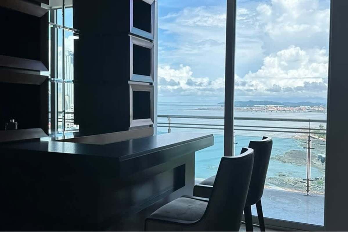 Stylish dining bar area with floor-to-ceiling windows ocean view PH Ocean Reef Punta Pacifica Panama