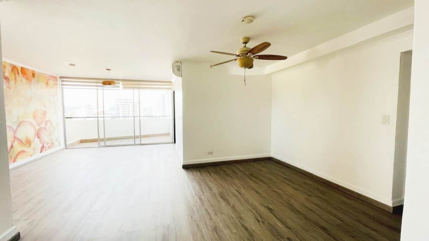 Bright living room with sliding doors, AC, floral wall, wood floors at PH El Carmen Tower Panama City