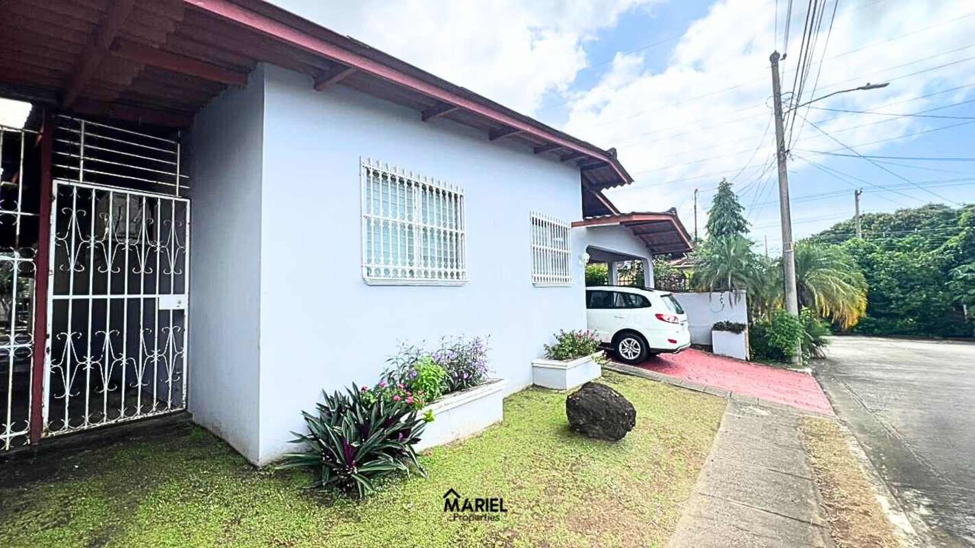 Light blue house exterior with covered carport corner view in Lomas del Golf Panama