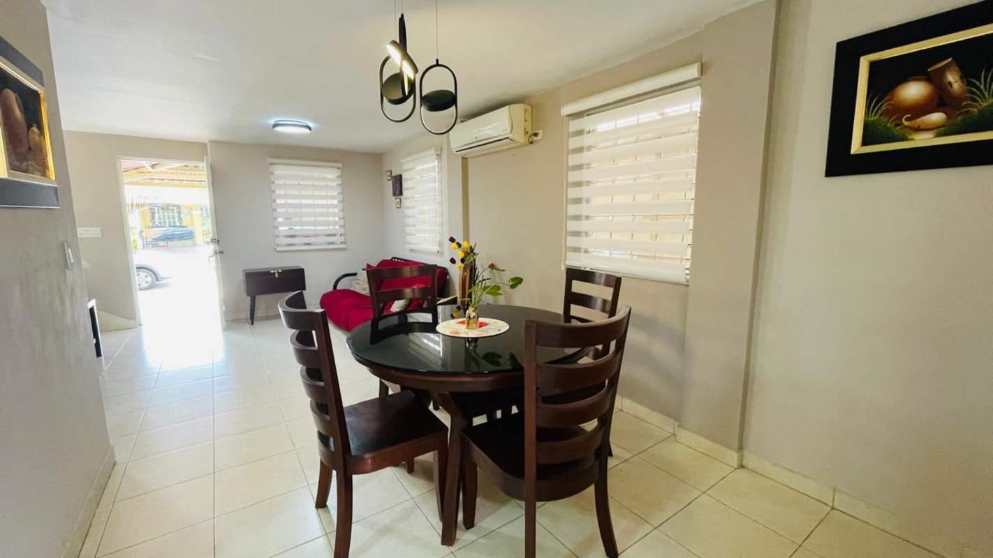 Bright dining area with glass table and chairs next to large window in Dorado Lake Condado del Rey Panama