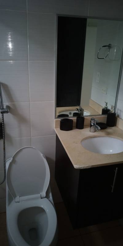 Apartment bathroom with vanity mirror, sink, tiled walls Transistmica Panama City