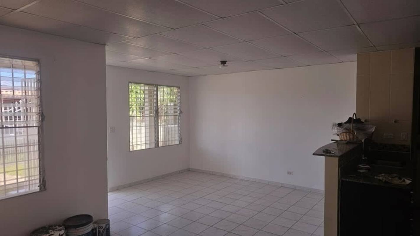 Bright living room with tiled floors, windows and dining space in house for sale Panama