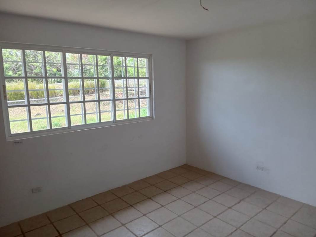 Sunlit bedroom with ceramic tile, large grid window at Hacienda Country Club Cerro Azul