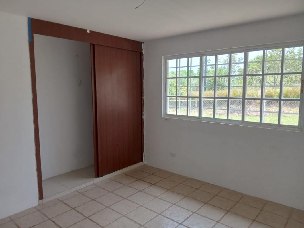 Minimalist bedroom with tiled floor, large window, built-in closet in mountain home Panama