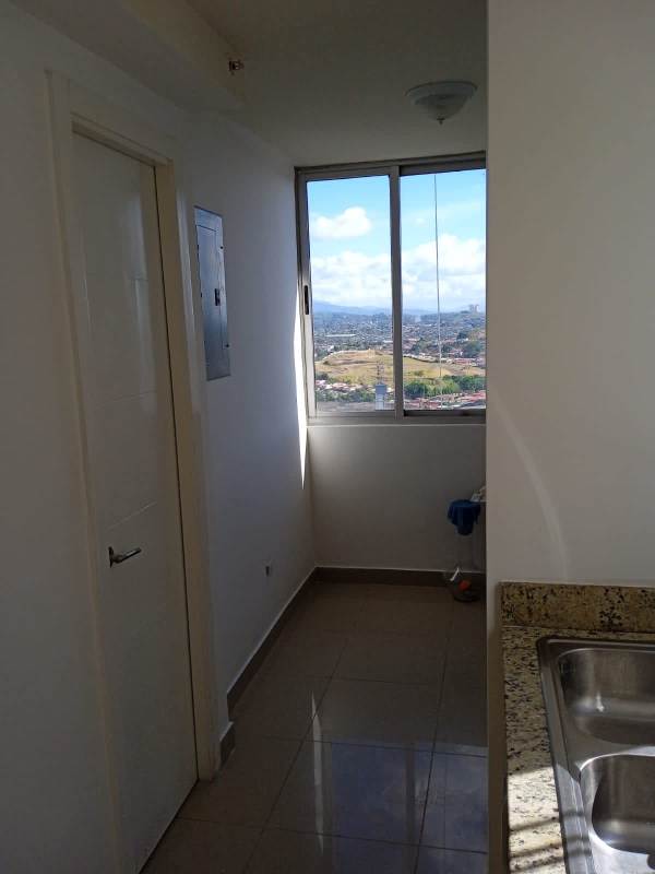 Living room with tiled floor and sliding door to balcony city view in Edificio Rokas Panama