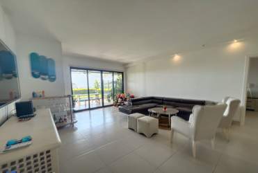 Elegant living and dining room with floor-to-ceiling glass, terrace access, ocean views Punta Caelo condo Panama