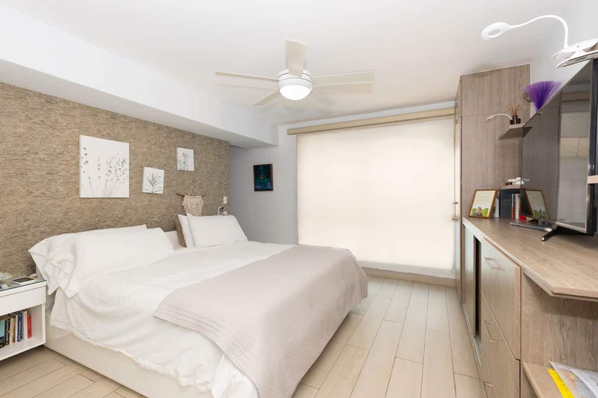 Master suite with ceiling fan, large bed, and ocean city view PH Blue Park Avenida Balboa