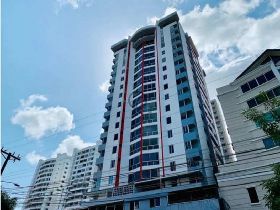 Modern kitchen with wood cabinets, black countertop, and appliances in Panama apartment rental