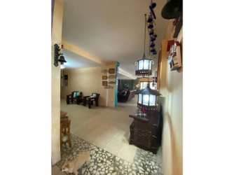 Spacious living room with turquoise accent, stone wall, leather sofas in Playa Blanca duplex