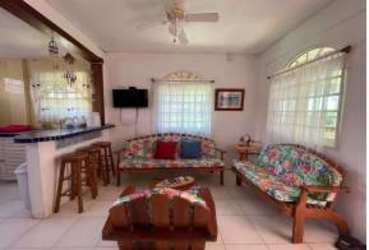 Open living area with breakfast bar floral sofas windows Isla Grande Panama