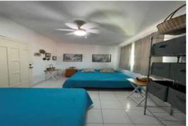 Dual bed guest room with ceiling fan and blue decor Isla Grande Panama