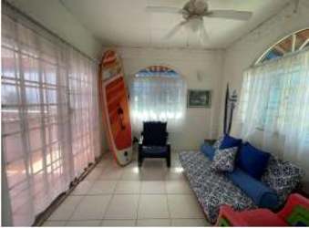 Sunroom filled with natural light surfboard colorful Caribbean villa Isla Grande Panama