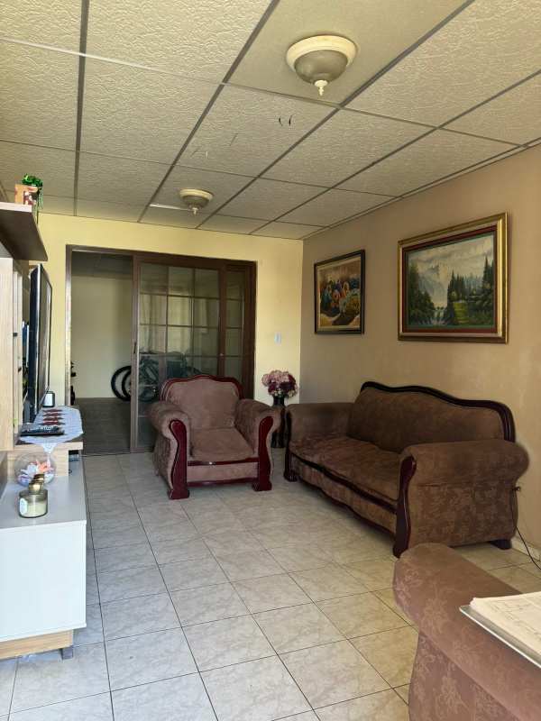Simple galley kitchen with stove and refrigerator in Villas de Don Bosco house Panama City