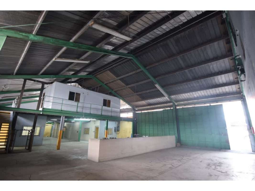 Interior warehouse space with concrete floor, chain-link fence and gated section Panama City
