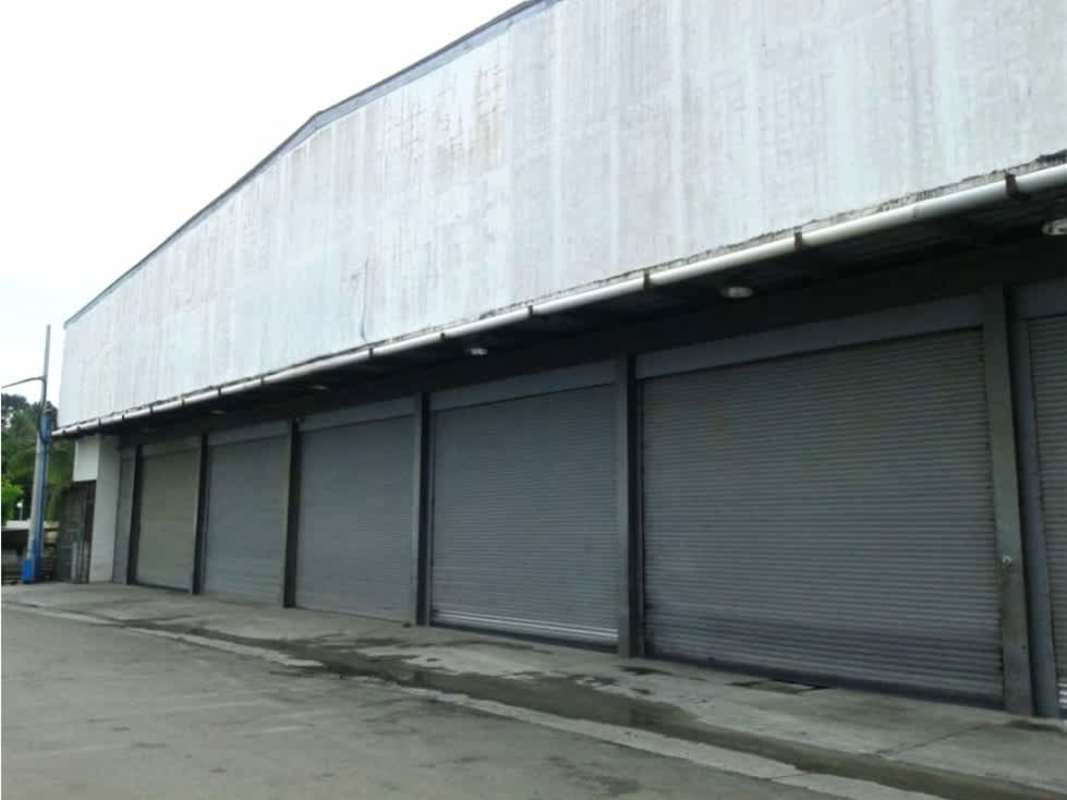 Street view large industrial warehouse concrete facade Llano Bonito Panama