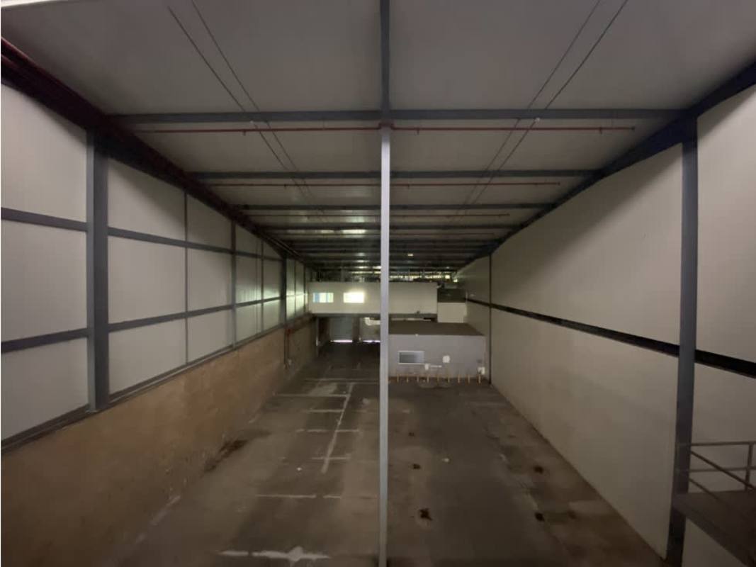 Empty high-clearance warehouse interior in Villa Zaita, concrete floor, exposed beams