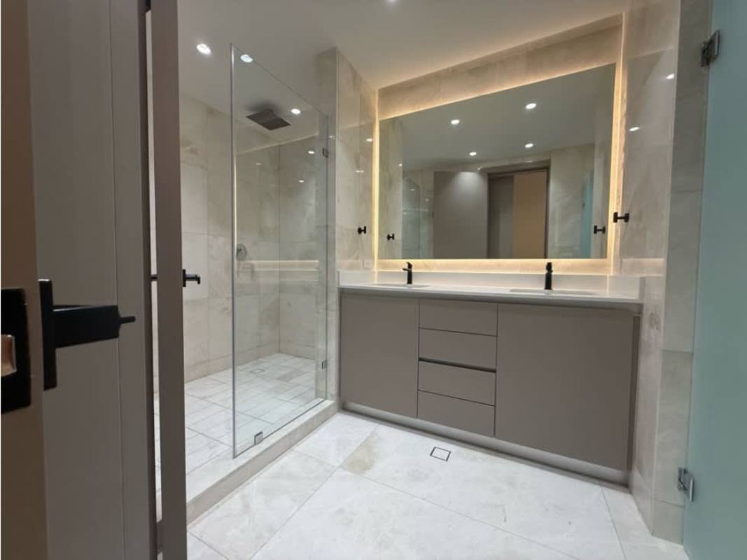 Spacious bedroom with large windows, upholstered bed, wood accent wall PH Ocean Front Panama