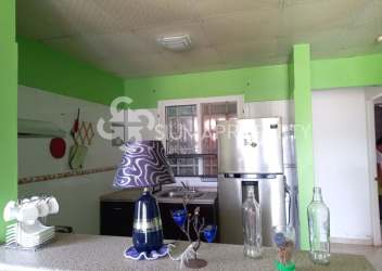 Open concept living room with green walls, red sofa, and dining space at Urbanización El Edén