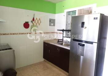 Kitchen with appliances, green accent wall, stainless fridge at Urbanización El Edén