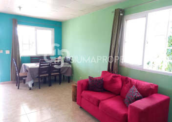 Bright open plan living dining area with red sofa at El Edén community, Arraiján