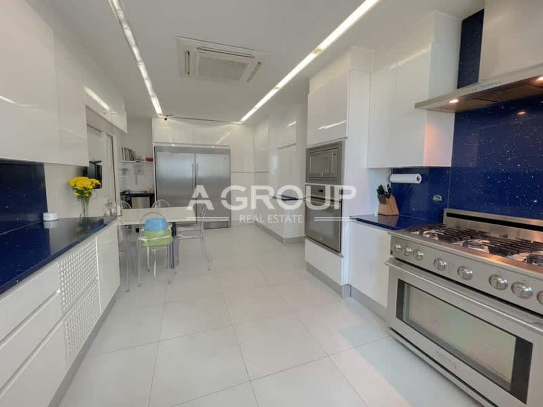 Bright modern kitchen with Italian cabinetry and blue speckled backsplash in Aventura Tower Punta Paitilla Panama