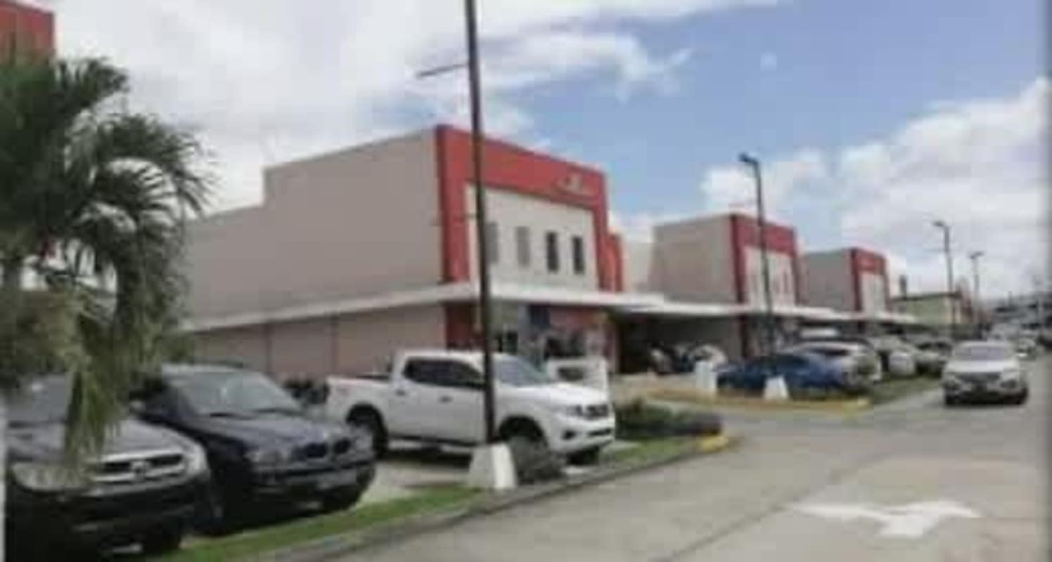 Exterior of shopping plaza with palm trees, storefronts, and parking Brisas del Golf Panama