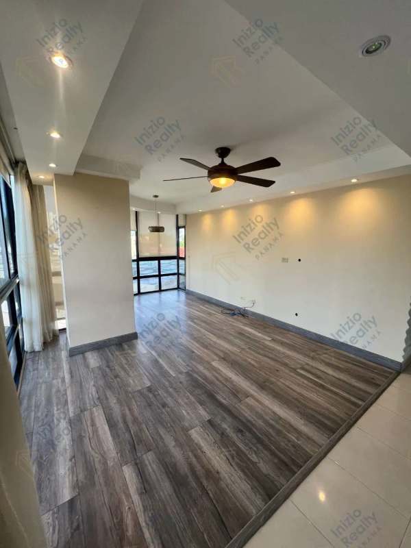 Contemporary kitchen with granite countertops and wood cabinets in Panama City apartment