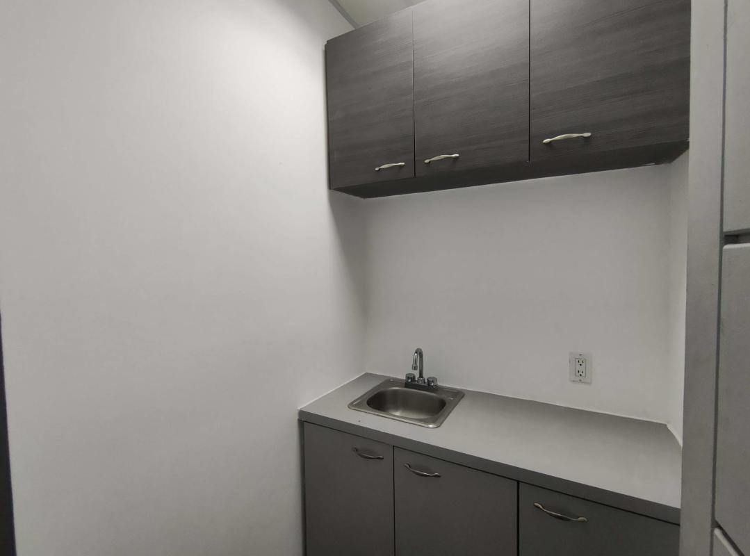 Small office kitchenette with sink and cabinets in modern commercial tower Punta Pacifica Panama