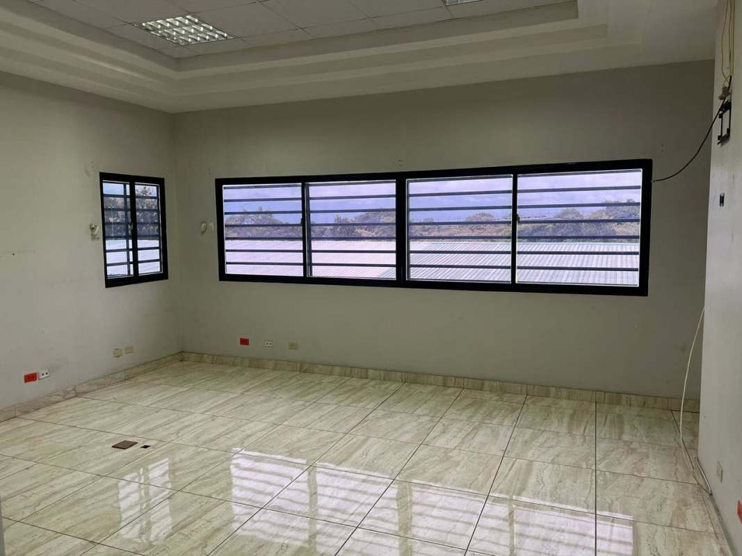 Spacious office space with large barred windows tiled floors in commercial building Panama