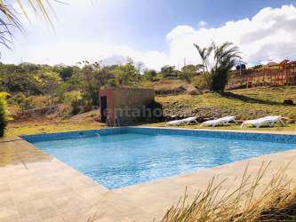 Outdoor pool area surrounded by mountain landscape and lush garden in Chica Panama