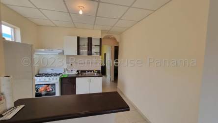 Simple kitchen with stove, refrigerator, and cabinets in Montelimar La Chorrera house