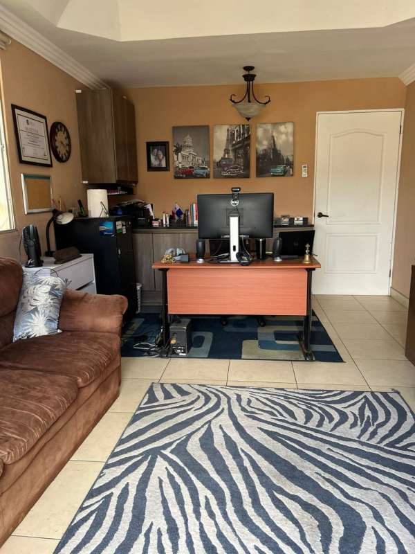 Spacious home office with desk, sofa, decor and tile floors in PH Paseo Dorado Panama City