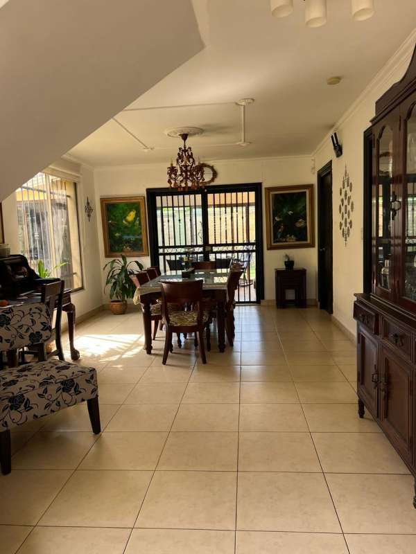 Dining room with chandelier, large windows, natural light and wood furniture in PH Paseo Dorado Panama