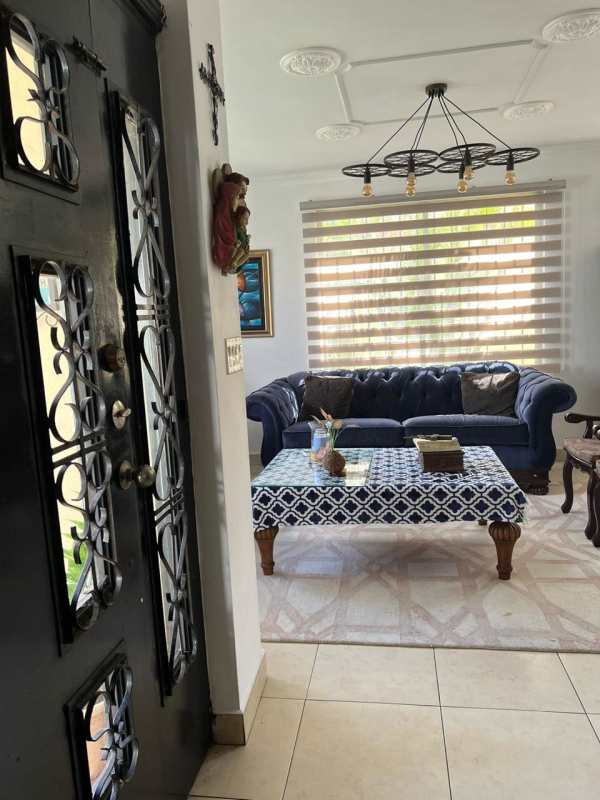 Living room with navy tufted sofa, patterned carpet, chandelier and modern decor in PH Paseo Dorado Condado del Rey