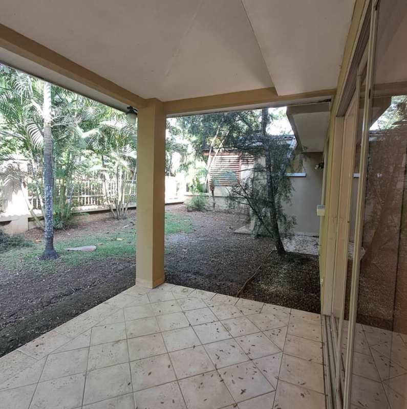 Covered outdoor terrace with tiled flooring and fenced garden at Embassy Club Clayton Panama