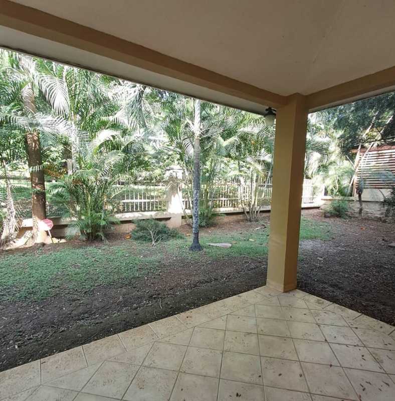 Covered balcony and tiled patio overlooking lush garden at Embassy Club Residences Clayton Panama