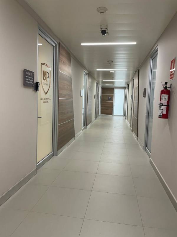 Modern corridor with glass doors, security cameras, wood accents in Costa del Este commercial building