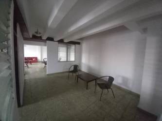 Living dining space with exposed ceiling beams, tiled floor, windows, Chitré rental