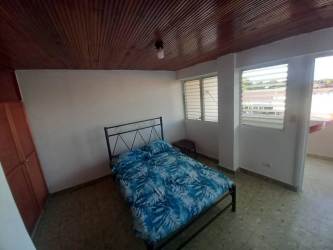 Bright bedroom with twin beds, windows, wooden ceiling, tiled floor Chitré apartment