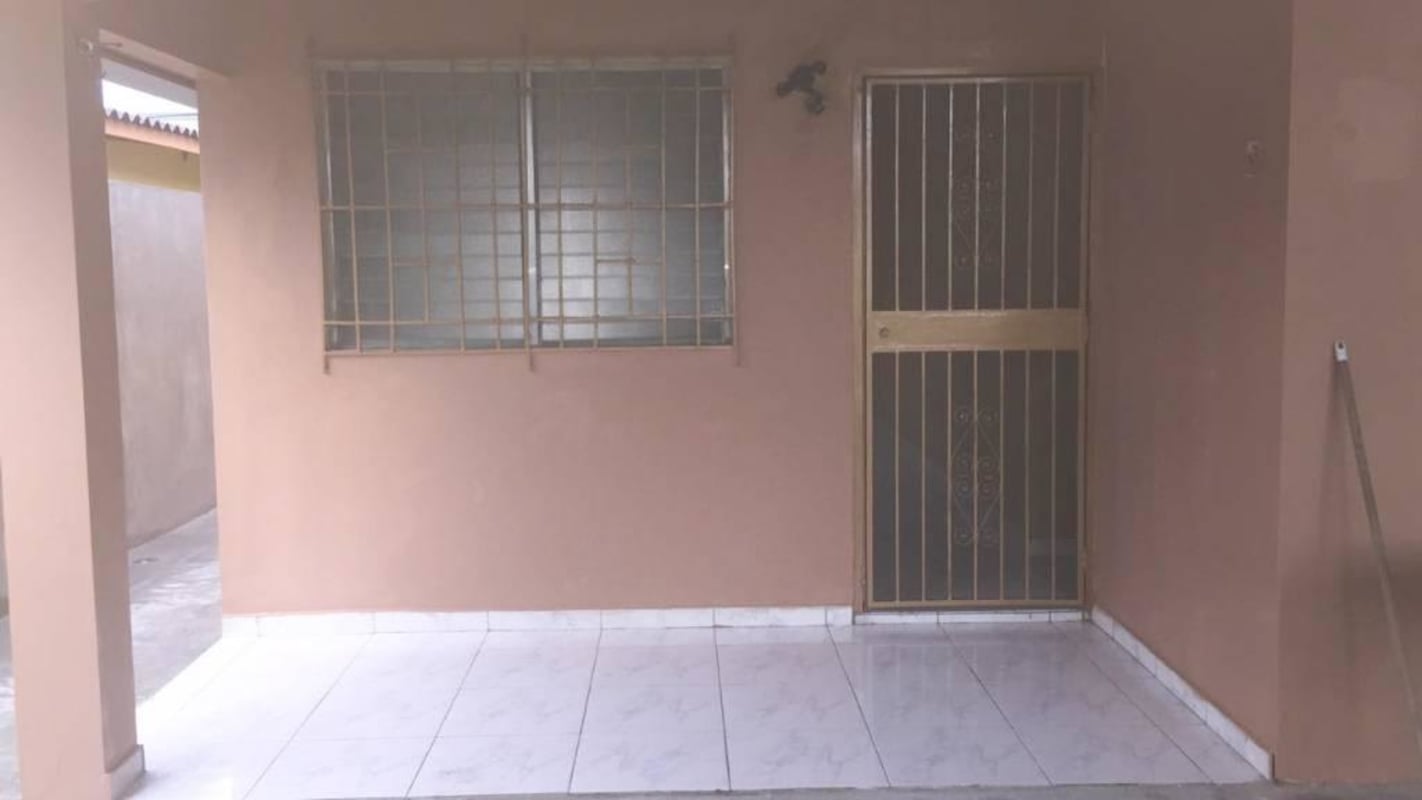Covered porch with iron security door and barred window at Villa Zaita Panama house