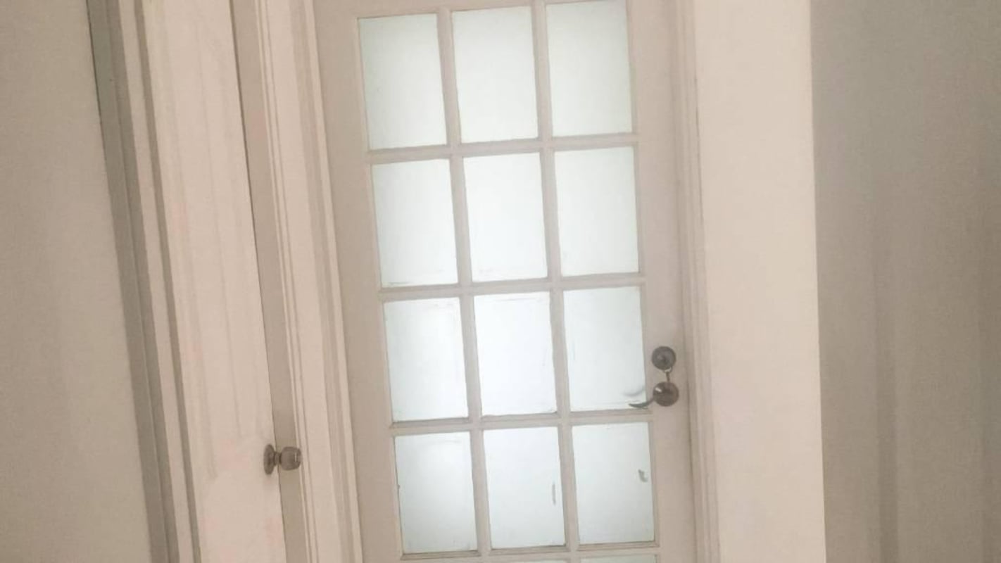 Interior corridor with white French glass door and white walls at Villa Zaita house Panama