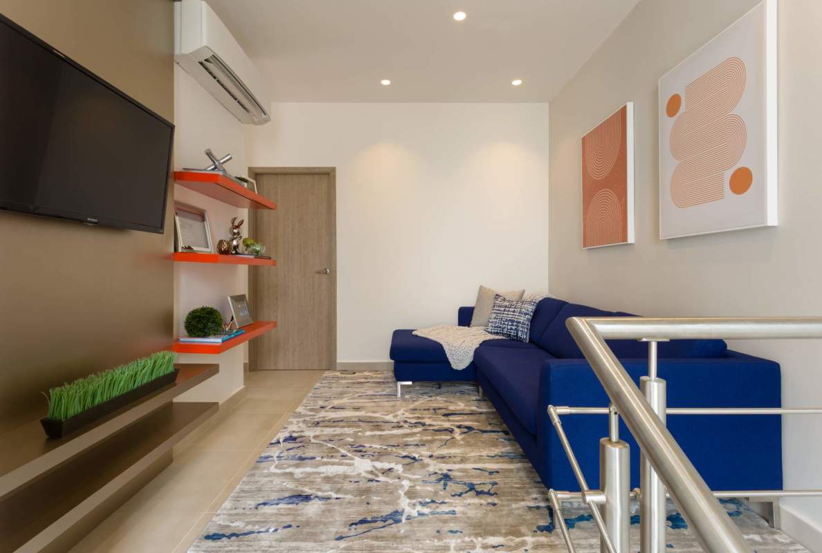 Contemporary living room with blue sectional sofa, wall TV and decor Costa Sur Panama