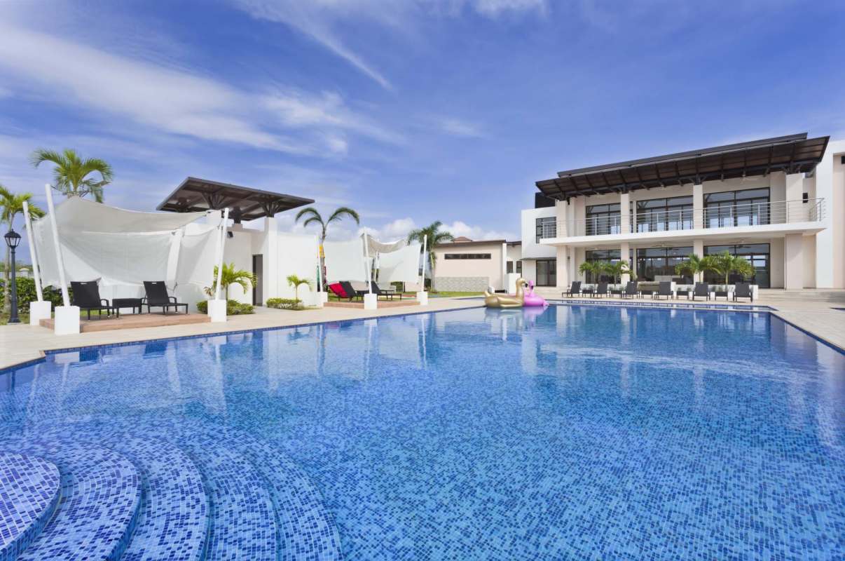 Luxury swimming pool with lounge chairs shaded cabanas Costa Sur Panama