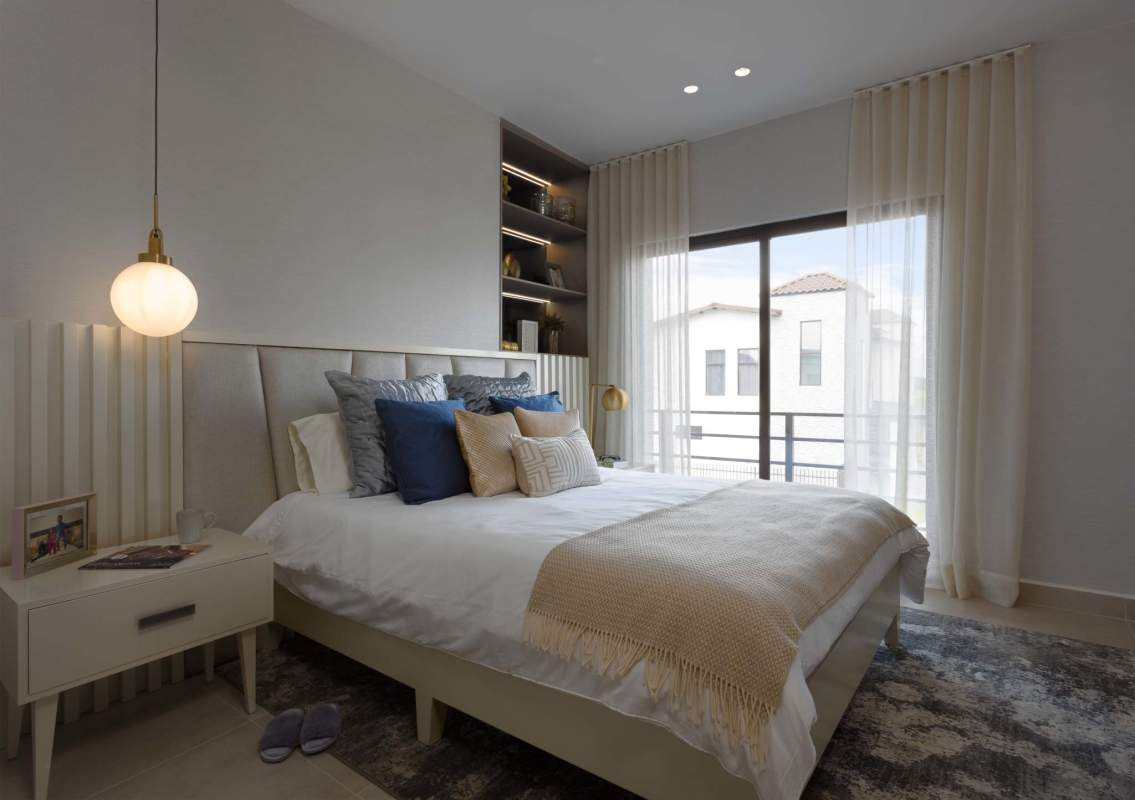 Modern bedroom with sliding balcony door and built-in shelving Costa Sur luxury homes