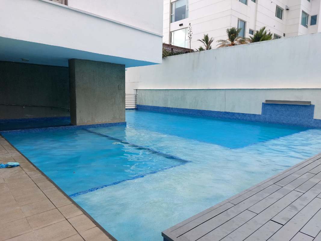 Modern outdoor infinity pool area at PH Bali Costa del Este surrounded by deck and shaded spaces