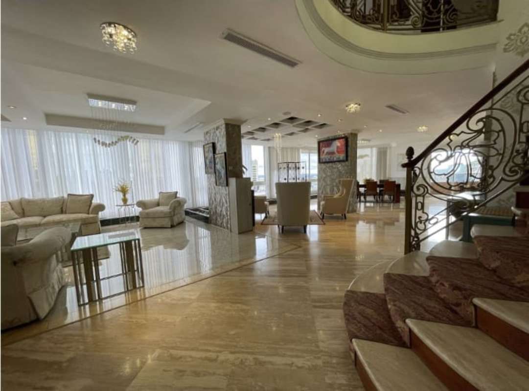 Modern kitchen with island, stainless steel appliances, marble floors overlooking city