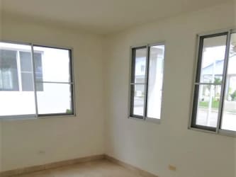 Clubhouse with tropical landscaping, beach style pool, palm trees in Playa Dorada Arraiján Panama