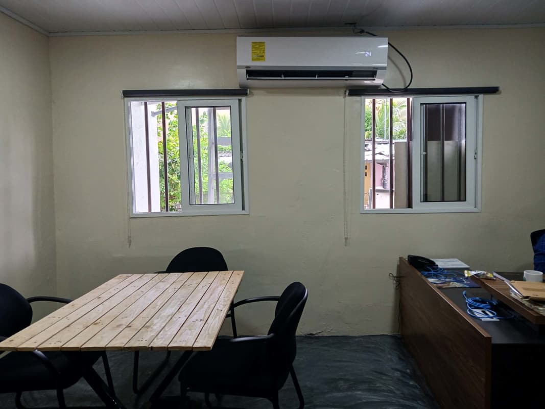 Compact office in Betania featuring sliding windows, AC unit, beige walls, ideal commercial space.