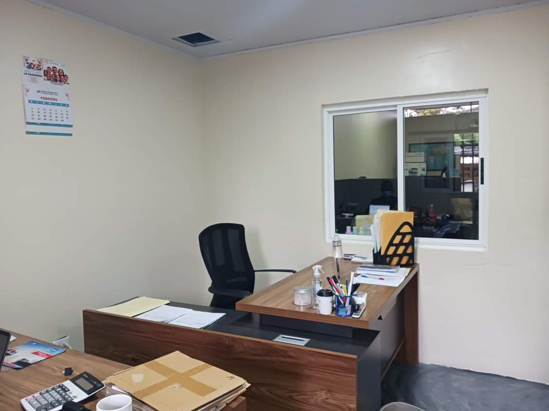 Shared commercial office interior in Betania with workstations, blue chairs, and partitions.