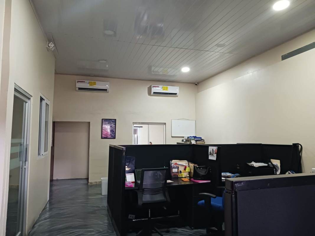 Private office room with glass desk and ventilation fan inside Betania commercial property.